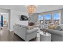 Cozy living room showcasing modern furniture, hardwood flooring, and lots of natural light at 7630 Rambling Vale, Cumming, GA 30028