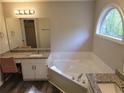 Bright bathroom featuring a soaking tub beneath a window and a granite vanity with ample counter space and storage at 153 Rockport Dr, Mcdonough, GA 30253