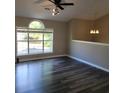 Bright living room featuring sleek, dark-stained hardwood flooring and a large window that offers plenty of natural light at 153 Rockport Dr, Mcdonough, GA 30253