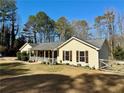 Single story home with cozy front porch, complemented by manicured lawn and mature trees at 4835 John Burruss Rd, Cumming, GA 30040