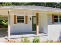 A view of the front porch with painted white brick and a green door at 1875 Creekside Ct, Decatur, GA 30032