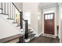 Warm foyer with hardwood floors, a staircase, a bench, and a wooden front door at 2541 Kickerillo Se Way, Atlanta, GA 30316