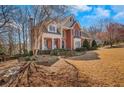 Brick home boasting lush landscaping, mature trees, and a welcoming front porch with rocking chairs at 4753 Outlook Ne Way, Marietta, GA 30066