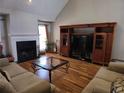 Cozy living room featuring a fireplace, hardwood floors, and comfortable seating arrangements at 3416 Haddon Hall Ct, Buford, GA 30519