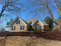 Charming brick home featuring well-manicured landscaping and a symmetrical, eye-catching facade at 828 Cedar Stream Ct, Loganville, GA 30052