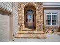Close up of front door with stone surround, transom window, and steps to the door at 1401 Rainey Rd, Temple, GA 30179
