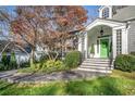 Inviting front entrance with stone steps, lush landscaping, and a bright green door that enhances curb appeal at 1225 W Wesley Nw Rd, Atlanta, GA 30327