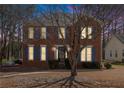 Charming two-story brick home with blue shutters illuminated at dusk at 1370 Wheatfield Dr, Lawrenceville, GA 30043