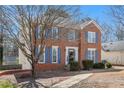 Attractive brick home with blue shutters, complemented by a mature tree and manicured landscaping at 1370 Wheatfield Dr, Lawrenceville, GA 30043