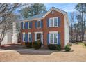 Traditional brick home with blue shutters, featuring a well-kept lawn and landscaping on a sunny day at 1370 Wheatfield Dr, Lawrenceville, GA 30043