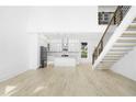 Open-concept living area with hardwood floors, staircase, and a view of the modern kitchen at 1650 Eastport Se Ter, Atlanta, GA 30317