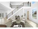 Bright living room featuring a staircase, contemporary furniture, and natural light streaming through large windows at 1650 Eastport Se Ter, Atlanta, GA 30317