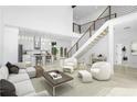 Bright, open-concept living room featuring modern decor, staircase, and seamless flow into the kitchen at 1650 Eastport Se Ter, Atlanta, GA 30317