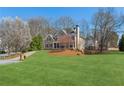 Expansive front yard with a mature tree and a view of the home's facade at 7270 Sheffield Pl, Cumming, GA 30040