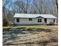 Single-story home with white siding and metal roof, complemented by a spacious yard at 7301 Staton Pl, Acworth, GA 30102