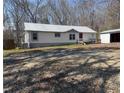 View of the side and front of single-story home with storage shed and gravel drive at 7301 Staton Pl, Acworth, GA 30102