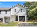 Two-story townhouse showcasing a white exterior, black garage door, and well-maintained driveway at 2113 Pine Tree Trl, Atlanta, GA 30349