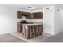 A modern kitchen features stainless appliances, a wood-clad kitchen island and tiled flooring at 2113 Pine Tree Trl, Atlanta, GA 30349