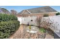 Outdoor patio with round glass table, wrought-iron chairs, privacy fence and lush landscaping at 970 Prance Dr, Kennesaw, GA 30144