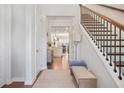 Inviting entryway featuring hardwood floors, a staircase, and a glimpse into the open-concept kitchen at 145 Treeside Ter, Fayetteville, GA 30214