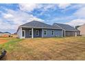 Expansive backyard featuring blue siding, sliding glass doors, and a well-maintained lawn at 246 Orwell Dr, Social Circle, GA 30025