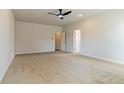 Spacious bedroom with plush carpeting, ceiling fan, and ample natural light from the doors at 246 Orwell Dr, Social Circle, GA 30025