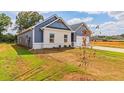 Well-maintained home exterior featuring complementary blue siding, landscaped yard, and concrete driveway at 246 Orwell Dr, Social Circle, GA 30025