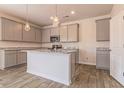 Modern kitchen featuring gray cabinets, granite countertops, stainless steel appliances, and a large island at 246 Orwell Dr, Social Circle, GA 30025