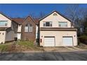 Lovely townhome featuring a well-kept front lawn, brick accents, and two-car garage at 705 Bridge Se Ln, Smyrna, GA 30082
