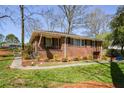 View of the brick home featuring an inviting front porch and nicely landscaped yard at 2780 Eastfield Se Rd, Smyrna, GA 30080