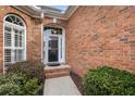 Inviting front entrance with brick facade, complemented by lush greenery and elegant arched windows at 348 Lauren Ln, Woodstock, GA 30188