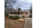 Charming ranch-style home with a stone chimney and a welcoming covered front porch at 582 S Cherokee Rd, Social Circle, GA 30025