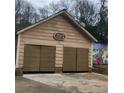 Two-car garage featuring dark doors and the house number above the door at 582 S Cherokee Rd, Social Circle, GA 30025