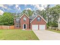 Beautiful brick home with an attached two-car garage, lush green lawn, and inviting curb appeal at 105 Kentwood Springs Dr, Hampton, GA 30228