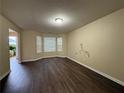 A spacious living room featuring dark wood floors, a bay window, and neutral-colored walls at 105 Kentwood Springs Dr, Hampton, GA 30228