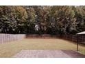 Expansive backyard with a privacy fence, mature trees, and a large patio for outdoor entertaining and relaxing at 11532 Ethan Ct, Hampton, GA 30228