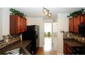Galley kitchen with dark wood cabinets, modern appliances, decorative backsplash and a view to the bright, plant filled backyard at 11532 Ethan Ct, Hampton, GA 30228