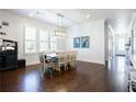 Bright dining room featuring hardwood floors, modern lighting, and a table with seating for eight at 341 Little Pine Ln, Woodstock, GA 30188