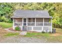 Charming cottage-style home featuring a screened front porch and a lush, wooded lot at 4481 Mclain Cir, Acworth, GA 30101