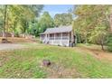 Lovely yard with cottage-style home featuring a screened front porch and a lush, wooded lot at 4481 Mclain Cir, Acworth, GA 30101