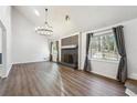 Spacious living room with cathedral ceiling, fireplace, modern light fixture, and ample natural light at 1108 Gwens Sw Trl, Lilburn, GA 30047