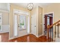 Bright foyer with hardwood floors, a glass-paned front door, staircase and views into the formal living space at 830 Village Manor Pl, Suwanee, GA 30024