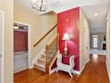 Hallway with wood floors, staircase and views of formal living and dining spaces at 830 Village Manor Pl, Suwanee, GA 30024