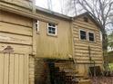 Exterior view with a brick foundation, siding and aging details at 339 Kelly Mill Rd, Cumming, GA 30040
