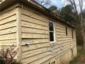 Close up exterior view exhibiting peeling paint, windows and aged siding details at 339 Kelly Mill Rd, Cumming, GA 30040