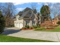 Exterior showcasing an attached three-car garage, stone accents, and lovely landscaping at 2502 Oak Hill Ovlk, Duluth, GA 30097
