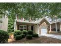 Charming two-story home with brick accent, red shutters, covered porch, and well-manicured landscaping at 4678 Ravenwood Loop, Union City, GA 30291
