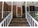 Close-up of the front porch with brick stairs and white railings of the home at 745 Queen Ann Ct, Stone Mountain, GA 30083