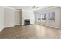Inviting living room featuring wood-look floors, a classic fireplace, and large windows for plenty of natural light at 780 Mccart Rd, Lawrenceville, GA 30045