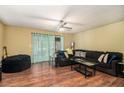 Relaxing living room featuring hardwood floors, a ceiling fan, and a comfortable dark sofa at 4 Quail Run, Decatur, GA 30035